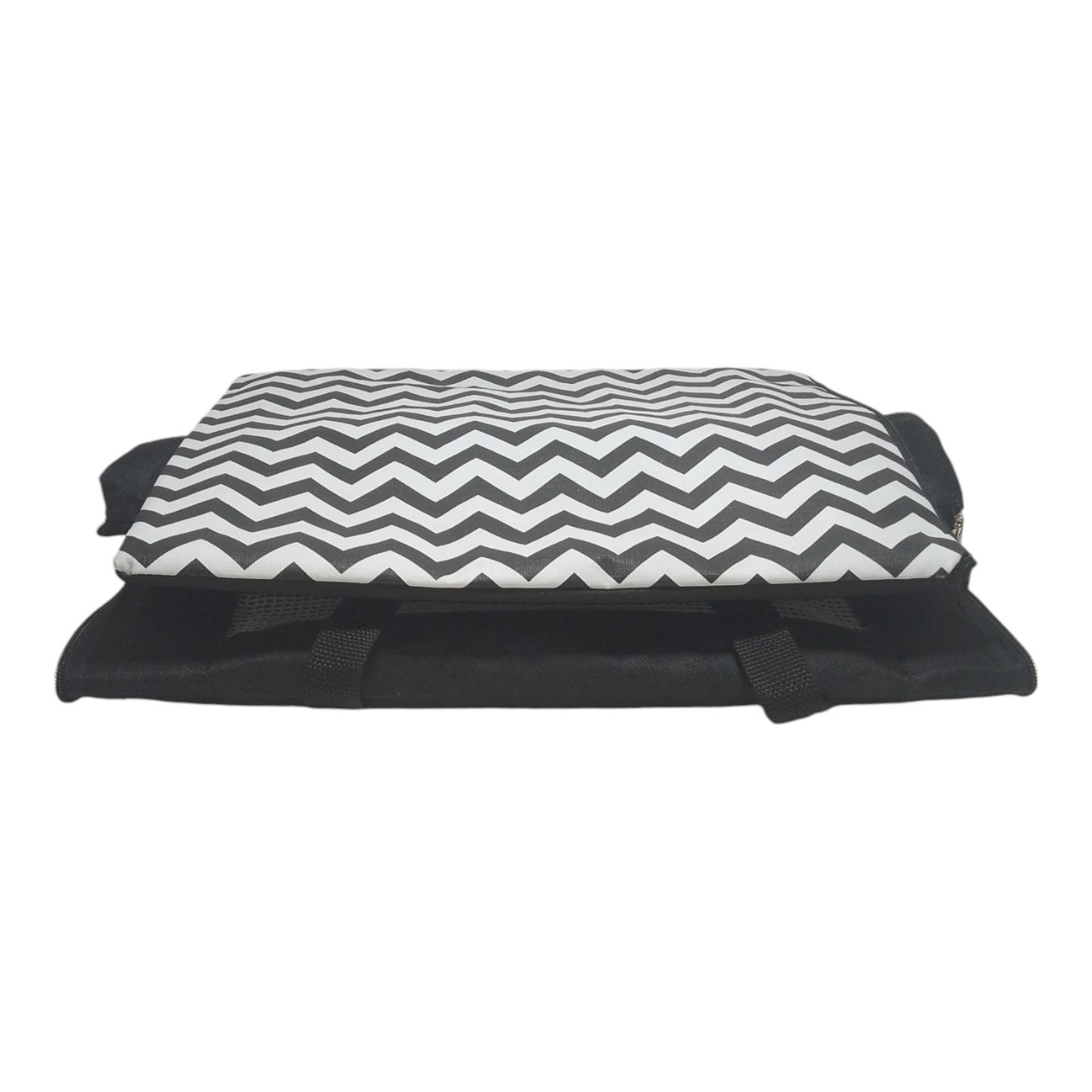 AereoBag preta dobrada vista frontal, com colchão removível de padrão chevron preto e branco sobre a mala. Base da mala visível com tela de ventilação e alças de mão. Design compacto que combina conforto para o pet e praticidade para armazenamento e viagens aéreas.